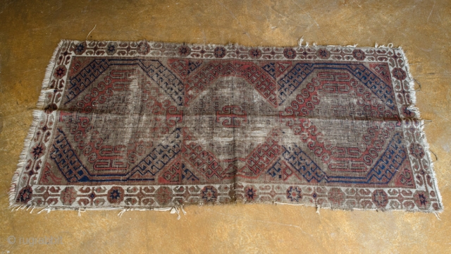 Antique Baluch. This is a very old and very worn Persian Baluch. It has a central Asian flair.

width: 2'5"
length: 4'7"
size category: 3'x5' and smaller
dominant colors: Red, Blue & Beige    