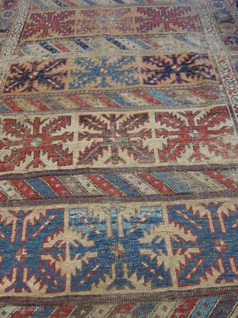 kurdish carpet, worn due to age, set on linen                        
