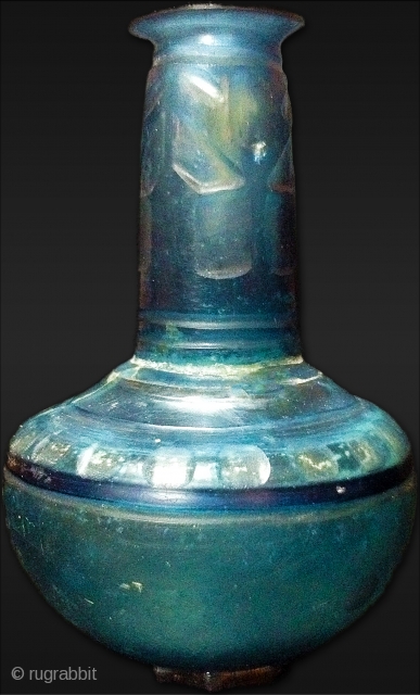 A wheel-cut glass Flask Persia 10th Century
Saphire blue, with globular body, tapering cylindrical neck and everted mouth with lip, the body facet-cut shoulder with two deeply cut grooves, the neck with three  ...