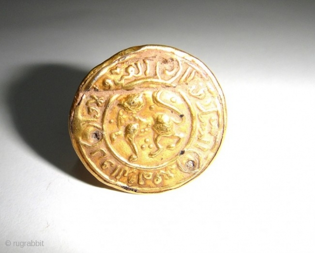 A SELJUK GOLD RING PERSIA 12TH CENTURY

The circular bezel with central engraved field of confronted lion faced toward its left surrounded by a raised border of spiralling arabesques around the circule border  ...
