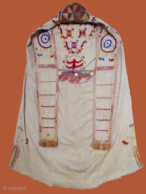 Woman's Jelak. South Uzbekistan, second quarter 20th century. Silk hand-embroidery on handwoven cotton with narrow stripes. Unlined. Silk woven and embroidered trim applied along edge; silk fringe; three pearl buttons. 35" length  ...
