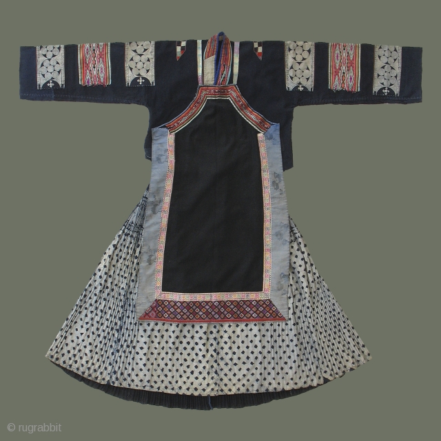 Buyi Woman's Costume - This distinctive costume is that of a married Buyi woman in Guizhou Province, SW China, and comprises a jacket, apron, and skirt. Silk embroidery and weaving, and batik  ...