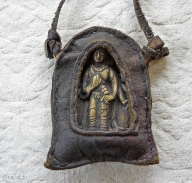Antique Tibetan Bronze Talisman in leather case.

This antique Tibetan talisman depicts a  bronze Buddha which is also displayed in a hand sewn leather casing. The Buddha is depicted as holding a  ...