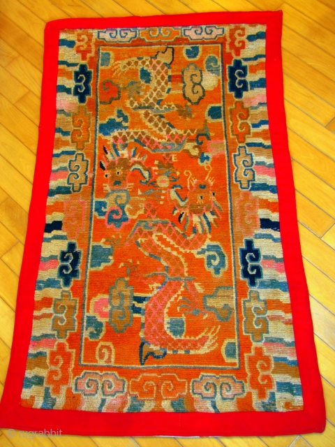 This is a striking example of an orange Tibetan ‘khaden’ rug depicting two dragons playing with the wish-fulfilling pearl. A khaden is a Tibetan sitting and sleeping rug, with a piece of  ...