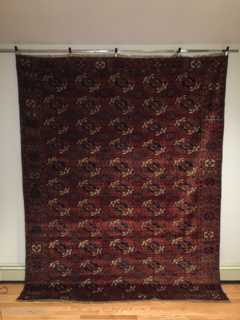 Tekke Main Carpet.  1st Half 19th Century.   Spacious red-purple field displays large rounded Tekke guls and secondary Gurbaghe guls connected by a fine line.  Cruciform star end borders  ...