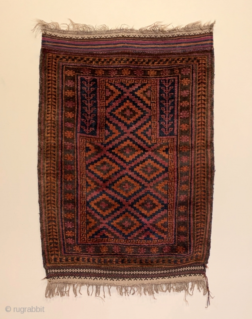 Antique Taimani Prayer Rug. W. Afghanistan. 1st Quarter 20th Century. Purple lattice frame ascending stepped diamonds radiating upwards into mihrab (prayer arch). 4’6” x 3’1”. 5 colors. Checkered 2 cord selvage. Lustrous  ...