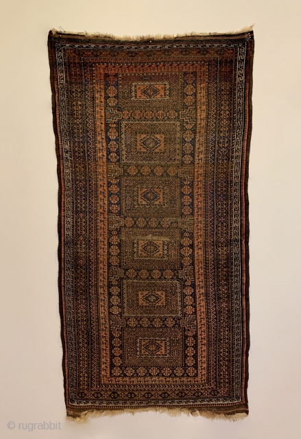 Antique Maadan Baluch Long Rug. Northeast Persia, Khorasan. This finely woven brown field offers a captivating inner border of rams. The central tribal design patterns are seen enclosed by 9 intricate borders.  ...