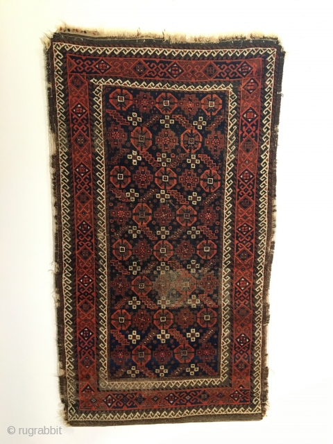 Antique Baluch Rug.  Northeast Iran.  2nd Half 19th Century.  Serrated leaves enclose stepped medallions on blue ground field.  Loss to selvage.  One area of localized wear.   ...