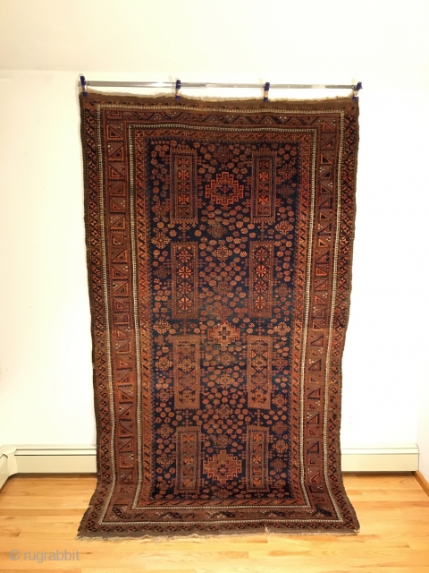 Rare Baluch Main Carpet. Timuri, Sangtshuli, Northeast Persia.  Mid 19th Century.  The vertical rectangles containing ’Sangtshuli’ rows of diamonds frame three stepped octagons on deep blue field.  All surrounded  ...
