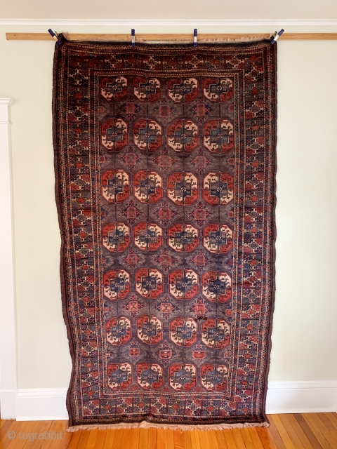 Turkmen Main Carpet. Circa Antique. Afghanistan. The ‘aina gochak’ main border frames a 4x7 gul layout of varying size on a rare purple ground. An interesting ‘gurbaghe’ secondary gul. Radiating bird heads.  ...