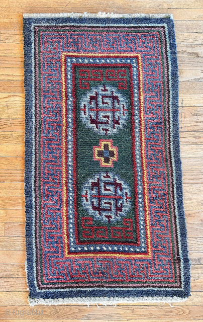 Here is an excellent example of a wang den, warp-faced back saddle carpet. This piece features a stunning green ground with two medallions and a single Tigma motif at the center. The  ...