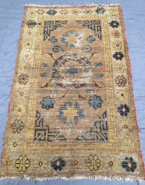 khotan oasis, small size khotan rug with an unusual center medallion, made in the early style with some early partly faded artificial dyes. worn. last quarter 19th century, 125 x 75 cm,  ...