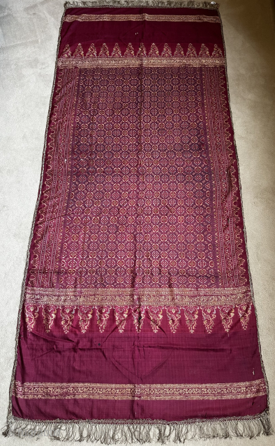 Shoulder cloth/kain limar. Palembang, Sumatra.
Fine silk cloth, weft ikat and songket on purple ground with green, yellow, blue tones. Ends of pucuk rebung design. Silk, gold metal thread, some weak areas. 198x86cm, ...