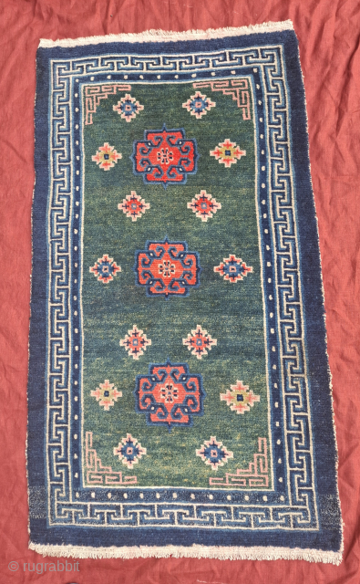 A wonderful tibetan Khaden with rare green.Three Eastturkestan inspired medallions. Late 19th century.  All wool. Bought in Kathmandu 1989 and with me ever since.86x154
cm. One professionally executed repair in the outer  ...