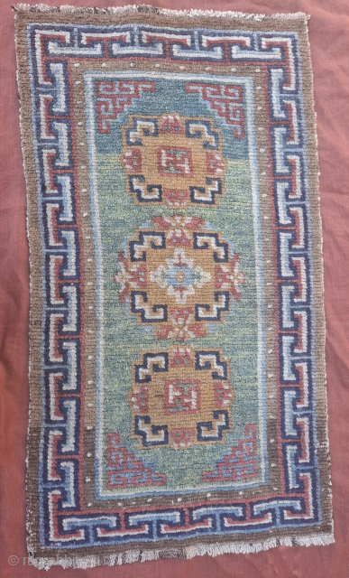 A wonderful tibetan Khaden from third quarter of 19th century.  All wool and vegetable dyes. Very good condition, no repairs 
119x66 cm so yes a bit smaller than usual.
Spectacular abrashes in  ...