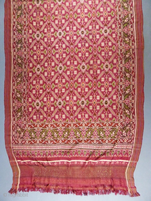 Early nineteenth century

India

Sumptuous red double silk woven shawl called Patola from India. Repetition of geometric patterns (hearts, flowers and stars) in cream, green and ocher drawing lozenges.
Borders of stripes and geometric friezes.  ...