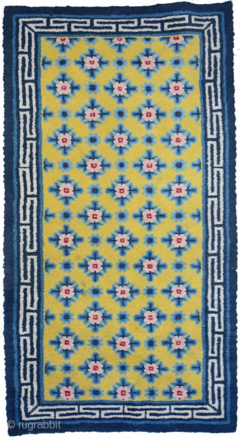 Very appealing medium sized Chinese carpet, most likely from the Ningxia area. The large 'Running T' main boarder anchors a richly saturated yellow center field with superimposed flower like rosette's set over  ...