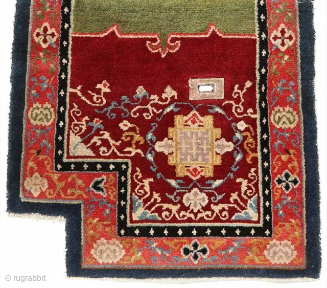 Striking Tibetan makden (‘under-saddle’ carpet) exhibiting a Khotan-like influence with an elaborate mandala motif surrounded by a fine trellis-like circular blue ‘necklace'. The main rose coloured outer border consist of alternating floral  ...