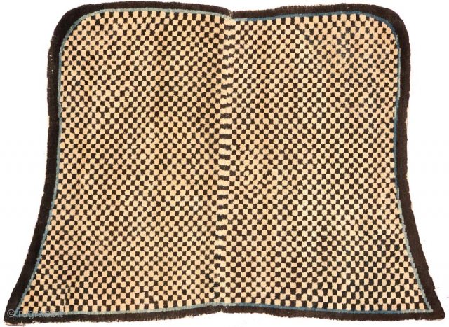 Tibetan 'butterfly-shaped' checkered makden, or under-saddle carpet. Black and white checkered center field, thin blue inner border, narrow black outer border. Circa 1920 with cotton warp and wool weft.  Size is;  ...