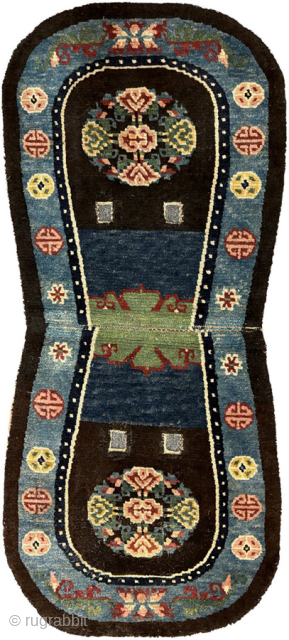 Oval shaped Tibetan makden, or under-saddle carpet, with floral roundels on either side in the main field and Inner Mongolian inspired circle motifs in the main border. Deep rich colours, especially the  ...