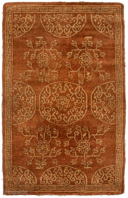 Reddish-brown coloured Tibetan seating carpet (or shugden) with yellow floral motifs encased by a simple T border; the entirety of which consists of just the two aforementioned colours. The main field consist  ...