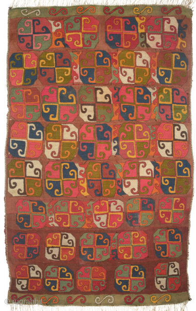 This kilim suzani from Central Asia is made of eight narrow strips of woollen warp-faced plain weave (circular photo, ultra close-up), first hand woven on a crude portable loom, then stitched horizontally ...
