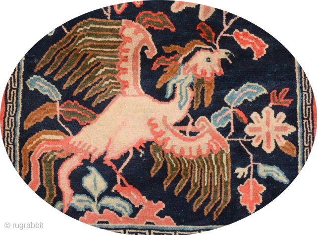 Tibetan under-saddle carpet (makden) featuring a phoenix on a midnight-blue center field surrounded by branched leaves. The shape is the so-called 'butterfly type' although the ‘wings’ are not as exaggerated / pronounced ...
