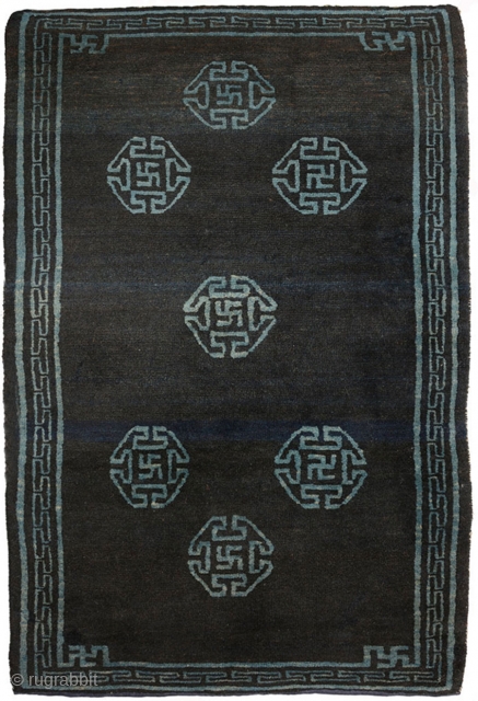 Very attractive Tibetan blue seating carpet with seven small mandala-like ‘medallions’ floating in the main field, each enclosing an auspicious swastika or sauswastika (i.e. a reverse swastika), with a 'T' shaped meander  ...