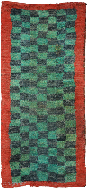 Tibetan three panelled checkered tsuktruk, abrashed throughout, the checkered pile center is of alternating blue-green and dark blue 'squares' which are surrounded by a red pile border that mimics the red covered ...