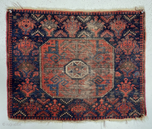 Antique Baluch octagon bagface with interesting archaic drawing but very rough condition. Good saturated natural colors including rich reds and multiple blues. Very low pile with heavy brown oxidation. Thin cloth like  ...