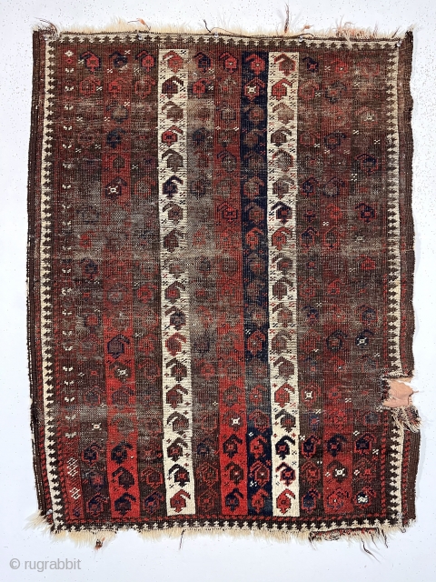 Early Baluch rug with interesting and archaic striped or “cane” design. Overall very rough with areas of foundation exposed and no pile. All natural colors including an excellent saturated red. Remnant original  ...