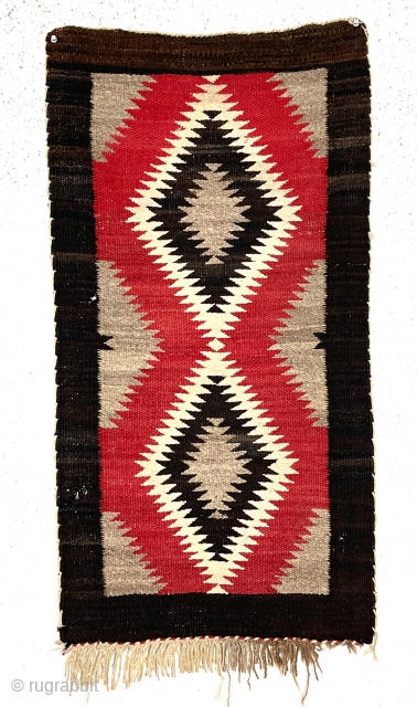 Older little Navajo weaving. Saddle blanket? Pretty natural wool colors and a rich saturated red. No color run. Fair condition for age. I see a couple small dime sized holes in border.  ...