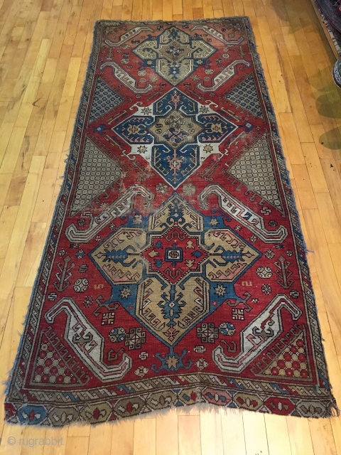 Old large Caucasian rug. Interesting design reminiscent of early karrabaugh pieces. New England rug, as found, dirty, worn and rough as shown. I see one sewn up crease. Selvages all trimmed and  ...