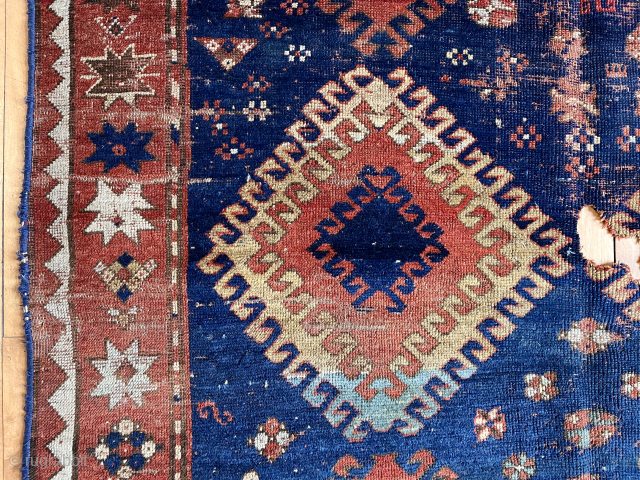 Early large Kazak rug in rough condition. Bold design with all natural colors. Lovely greens. Creases, heavy wear, well placed hole. Badly abused but still brings a smile. Priced accordingly. Mid 19th  ...