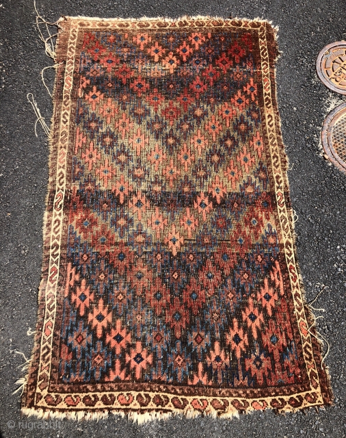 Antique Turkish knotted Baluch rug with an interesting and uncommon design. As found, in rough condition with heavy brown oxidation, wear, edge unraveling, loss. All natural colors. Nice floppy handle. Very dirty.  ...