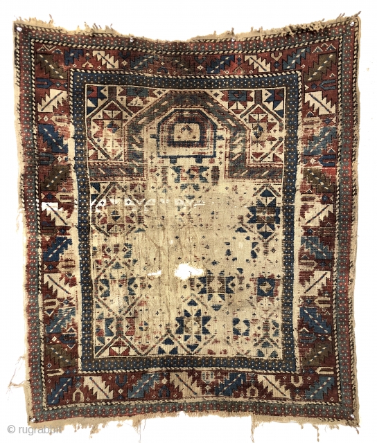 Antediluvian ivory ground Caucasian prayer rug or at least what remains. Possibly early shirvan. Appears to have all wool foundation but interestingly has an area of original white cotton pile. Heavily worn  ...