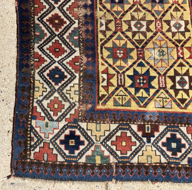 Early yellow ground Caucasian long rug with some unusual design features and excellent saturated natural colors. Kazak? Gendge? Eye catching uncommon ivory border. Unfortunately damaged with a large tear as shown. As  ...