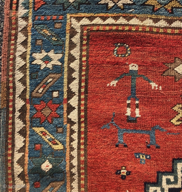 Antique small Kazak rug in good untouched condition with spacious drawing featuring charming large stylized humans. All natural colors including an attractive tomato red ground, sky blue border and an unusual lovely  ...