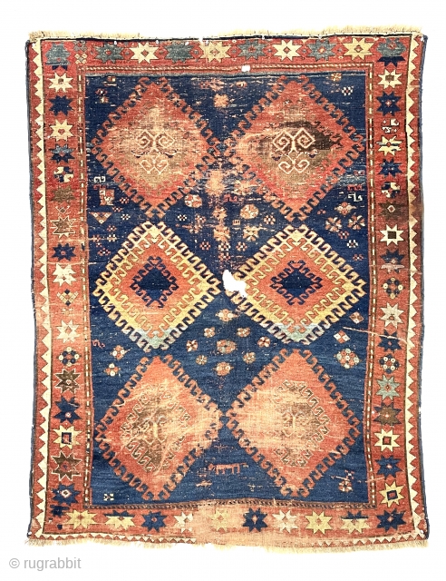 Large Kazak rug. Early? You decide. You might find it exciting or think rubbish and impossible to appreciate. An encyclopedia of condition issues including heavy wear and a good hole.  4’7”  ...