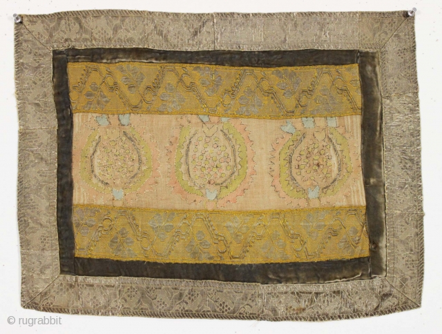 Small old something. Made up around an old central fragment, probably
anatolian, with added textile borders. Lots of metallic thread in the borders, a bit in the center. Cloth backing appears loose other  ...