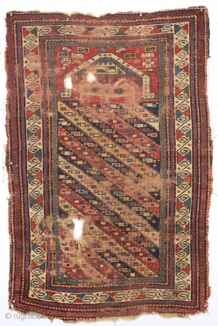 early kazak prayer rug with an unusual mihrab and a very attractive main border. As found, very, very dirty with low pile and scattered damage a shown. Unclear inscribed date. All good  ...