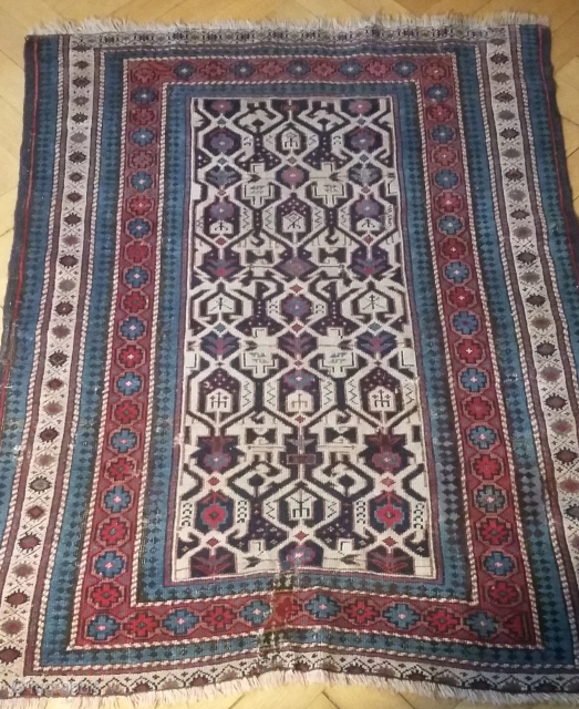 Kuba ( Konagend) 130/112 cm. 19th C.Loss of borders on top and bottom. Small repairs of corroded wool in the border, a tear has been reknotted.But....the beautiful field with its complex design  ...