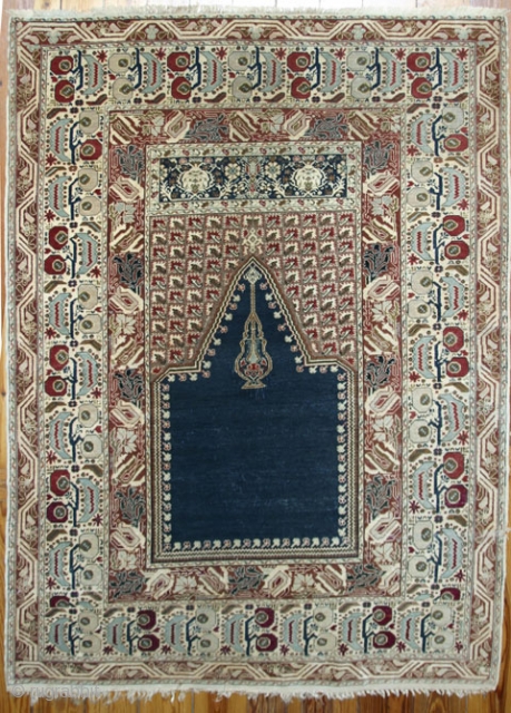 Gördes Prayer Rug. C.1900, or early 20th.cent. 135x185 cm. Full pile, typical Gördes coloring. Classical but very intricate borders. One minimal repair at selvages. Several small damaged spots within the Mihrab, difficult  ...