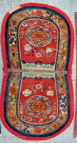 Tibetan Under Saddle Rug 49"x26.5".  More desirable oval shape with some signs of use. 1930s with cotton warps and wefts.  Typical colors for time period with great design.   