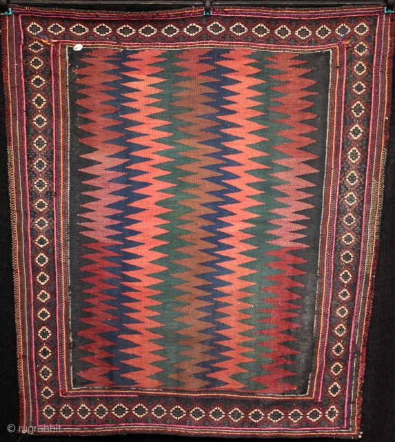 Old tribal kilim sofreh with Balouchi style soumac embroidered border and Afshar tribe style zig-zag field, cowrie shell in one corner and traces of bread dough in the other. Slightly trapezoid in  ...