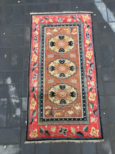 Tibet rug, camel background with three group flowers pattern, around red color full flower selvage. Size 152*83cm(59*32”) wool warp and weft. Good age          