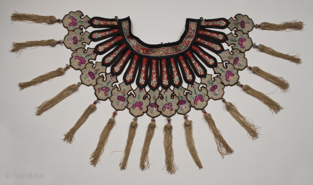 Cloud collar, China. Silk and cotton. 19th - 20th century. 15" (38 cm) from edge of collar to tip of fringe. Neck band is 15.5" (39.4 cm) long. Some areas of fraying  ...