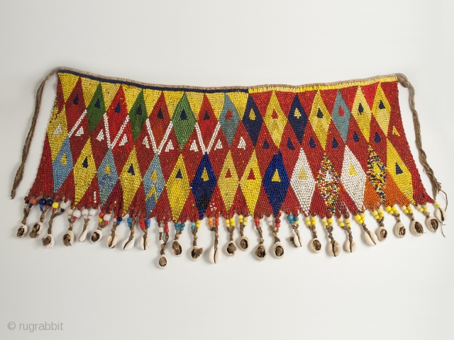 Pikuran (cache-sexe), Bana Guili people, Mandara Mountains, Cameroon. Seed beads, cotton string, cowrie shells, 19" (48.3 cm) wide by 9.5" (24 cm) high, mid 20th century or earlier.

The incredible variety of colored  ...