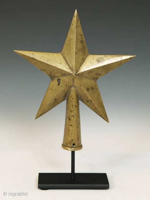 Star-shaped staff finial,
Africa.
Brass,
9" (22.8 cm) high by 6" (15.2 cm) wide by 2" (5 cm) deep, as based,
Mid 20th century             