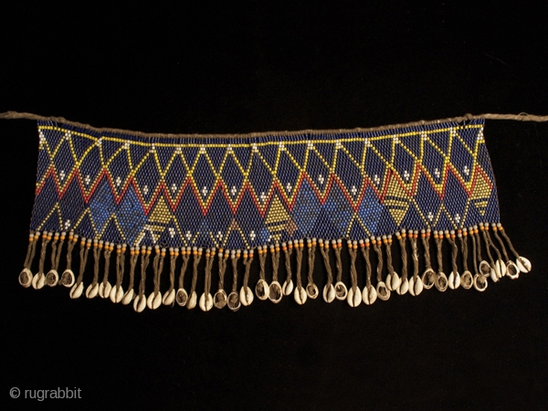 Pikuran (cache-sex),
Kirdi people, Cameroon.
Seed beads, cotton string, cowrie shells.
22" (56 cm) wide by 8" (20 cm) high.
Mid 20th century.
#1643              